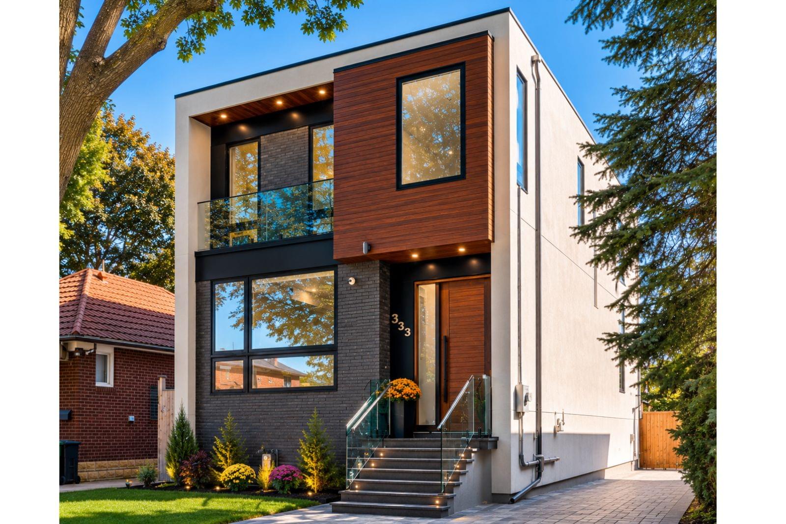 Modern custom infill home at 333 Woodmount Avenue, East York, Toronto, with stucco, ACM cladding, and dark brick cladding and lit entry, by Quadrant Architects
